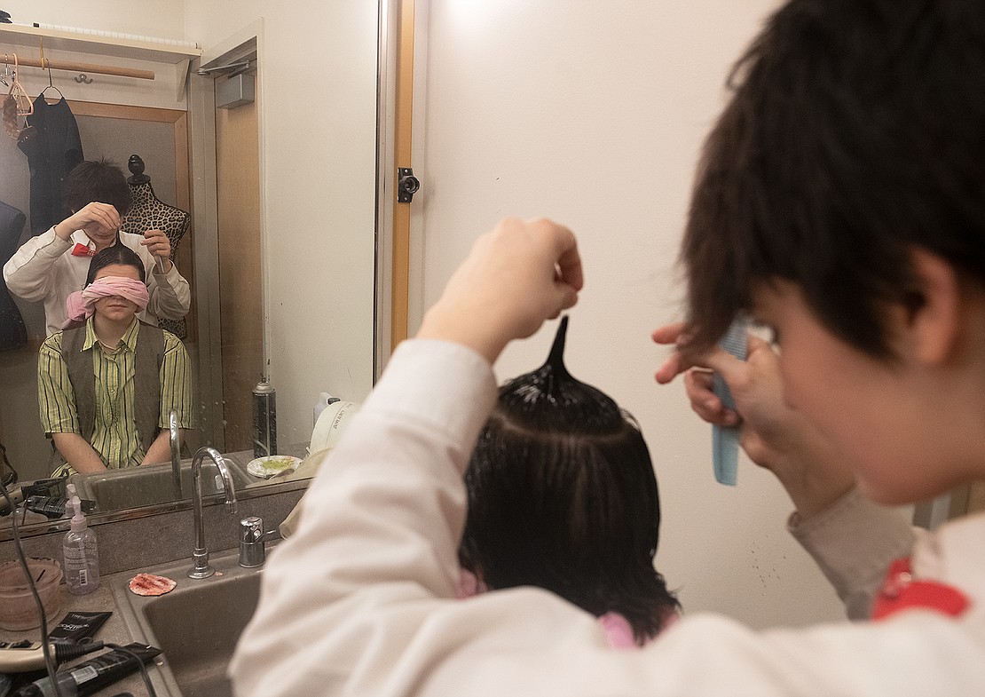 AJ Occhipinti spikes Kelly Kernan's hair while they wear a blindfold to maintain their confidence in the green room about an hour before Bellingham High School's show.