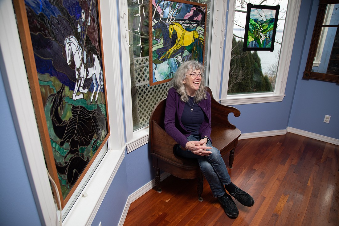 Three of Leslie Mason's stained glass pieces hang around her in the dining room of her Bellingham home. Many of her public works can be seen at Christ Episcopal Church in Blaine.