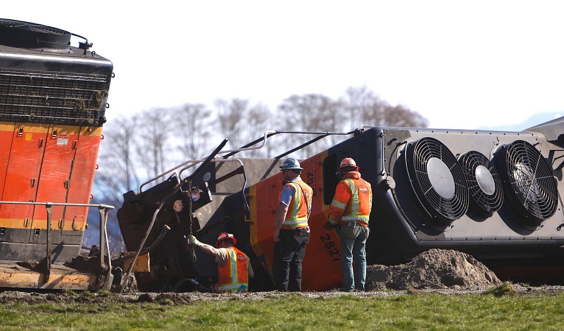 Crews examine an overturned locomotive around noon March 16. A Burlington Northern Santa Fe train derailed shortly after midnight on the Swinomish Reservation in Anacortes.