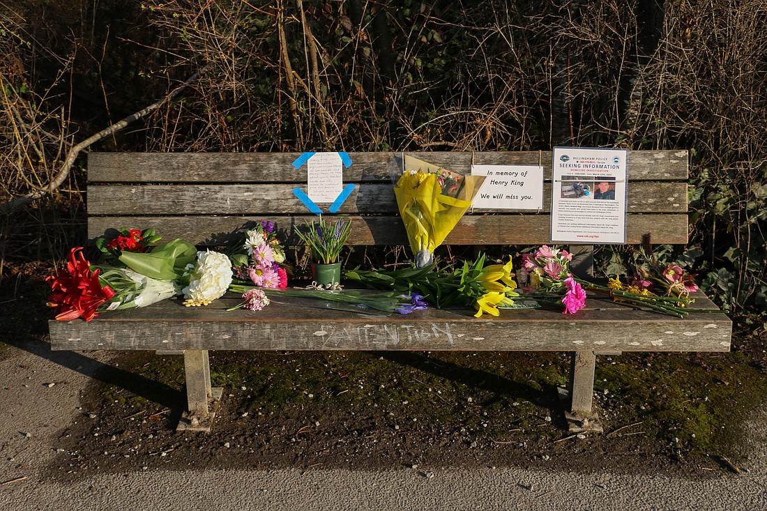 Dozens of people stopped on March 15 to ponder or leave flowers, notes and trinkets on a bench Henry King frequented on the trail between the Boulevard Park and Taylor Dock boardwalks. King was shot to death March 12 near Taylor Dock. Hundreds of community members recall talking to King about baseball, the birds and the bay along the high foot-traffic path.