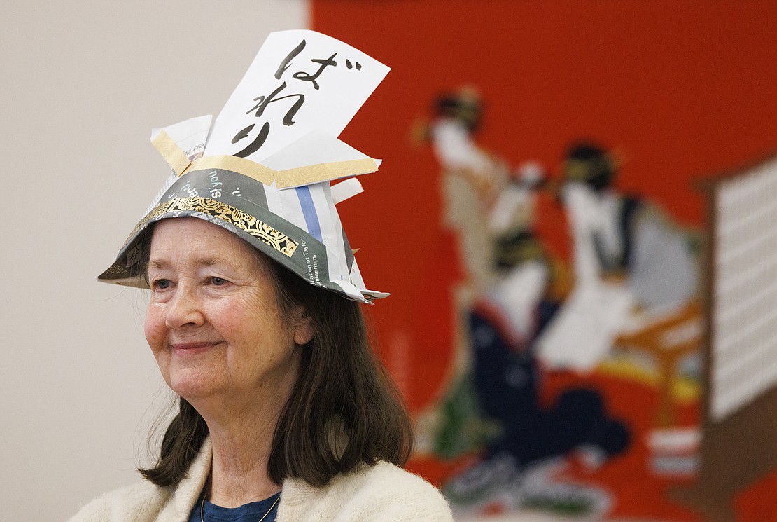 While watching a demonstration, Valarie Matinjussi wears a newspaper helmet with her name written in Japanese.