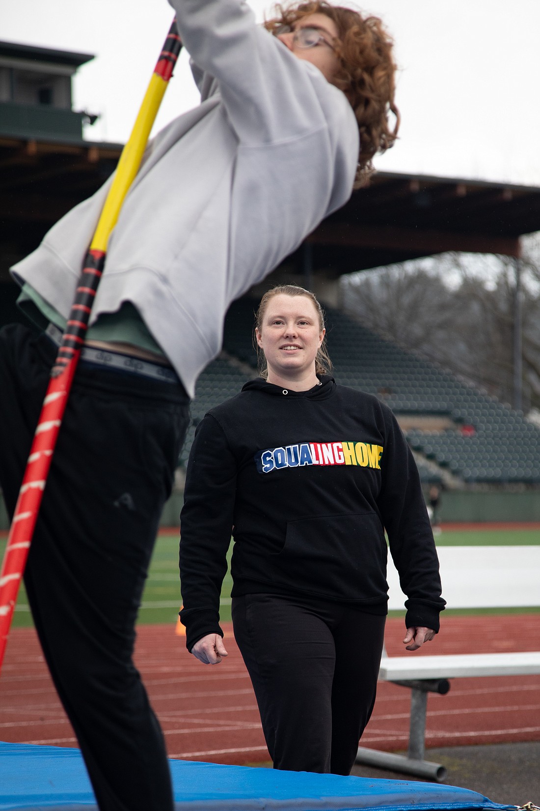 Dressed in her "SquaLingHome" sweatshirt, Morgan Annable coaches pole vaulting to students from three Bellingham high schools on March 20 at Civic Stadium. Annable is a former athlete and pole vaulter at Western Washington University and now works at Squalicum High School.