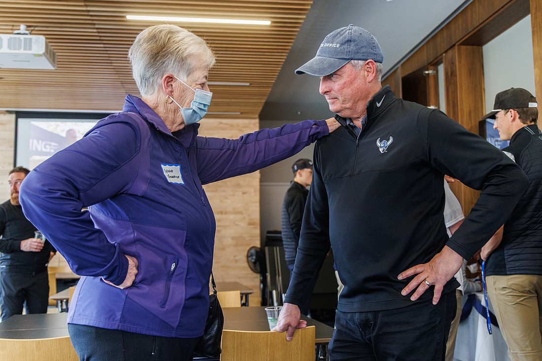 Former athletic director Lynda Goodrich puts a hand on the shoulder of now-retired Western Washington University athletic director Steve Card March 30 during his retirement celebration in the WWU Athletic Hall of Fame room. Card, who was hired by Goodrich, is retiring after 33 total years with Western.