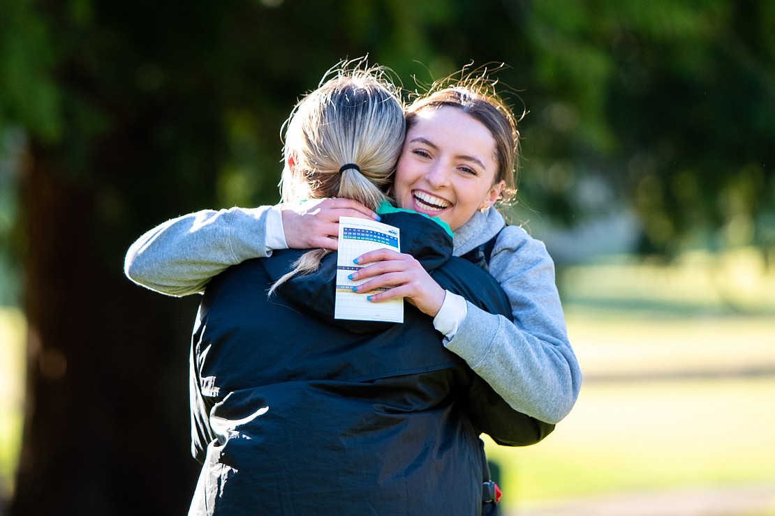 Sehome's Hannah Hochsprung hugs Lynden's Kinsley Rector March 30 after finishing the final hole of the 2023 Whatcom County girls golf championships at Sudden Valley Golf Course.