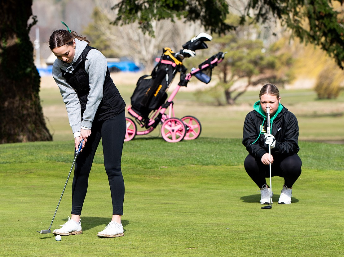 Sehome's Hannah Hochsprung putts the ball as Lynden's Kinsley Rector lines up her own putt.