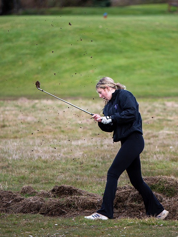 Nooksack Valley's Samantha Howe kicks up dirt after attempting to hit her ball out of a muddy ditch.