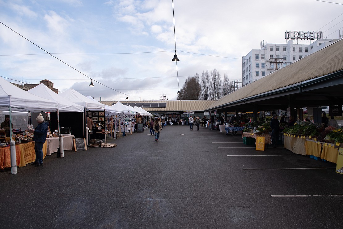 Vendors put the finishing touches on their booths moments before the Bellingham Farmers Market opens.
