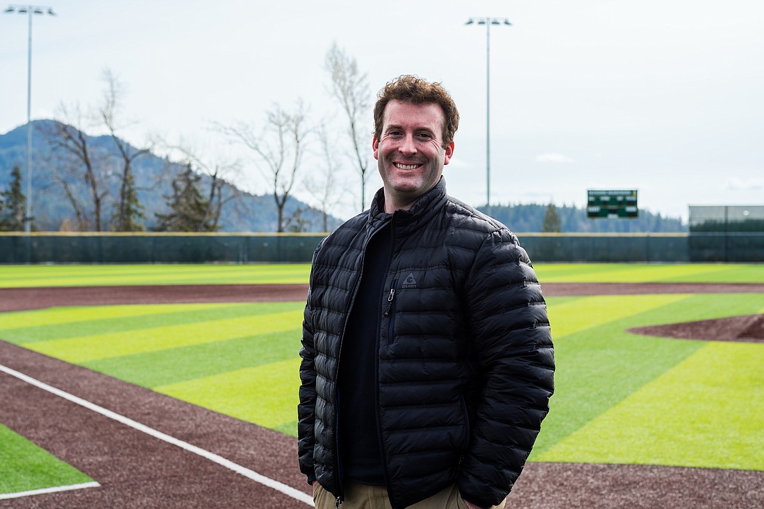 Dane Siegfried stands on the baseball field at Sehome High School. In addition to being the head baseball coach there, he is the operations and climbing wall coordinator at Western Washington University's Wade King Student Recreation Center and helps run the Bellingham Bells' spring break training.