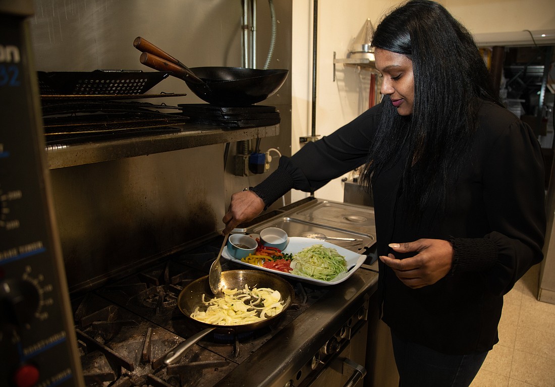 Sarah Chan cooks a cabbage stir fry with onions, bell peppers and spices March 27 at her Bellingham kitchen. Chan is the owner of Calypso Kitchen, a catering company, and recently started PNW Plateful, a nonprofit providing free meals to unhoused people and others in need.