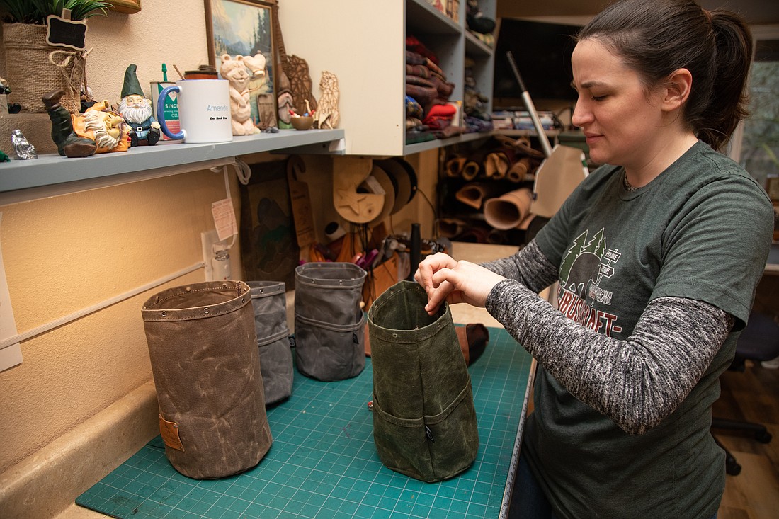 Amanda Dunkley adds grommets to bucket bags March 24 at the PNWBushcraft shop in Deming. Dunkley works with her family to make waxed canvas products for the outdoors.