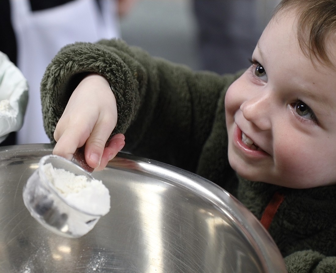 Norman Campbell, 3, scoops flour while making the dough for vegan cookies April 16 at Bloedel Donovan’s pavilion building. Campell said he was excited to share his creations with his two older siblings, who have also taken cooking classes with Tiny Onion Cooking School's founder, Annalee Dunn.