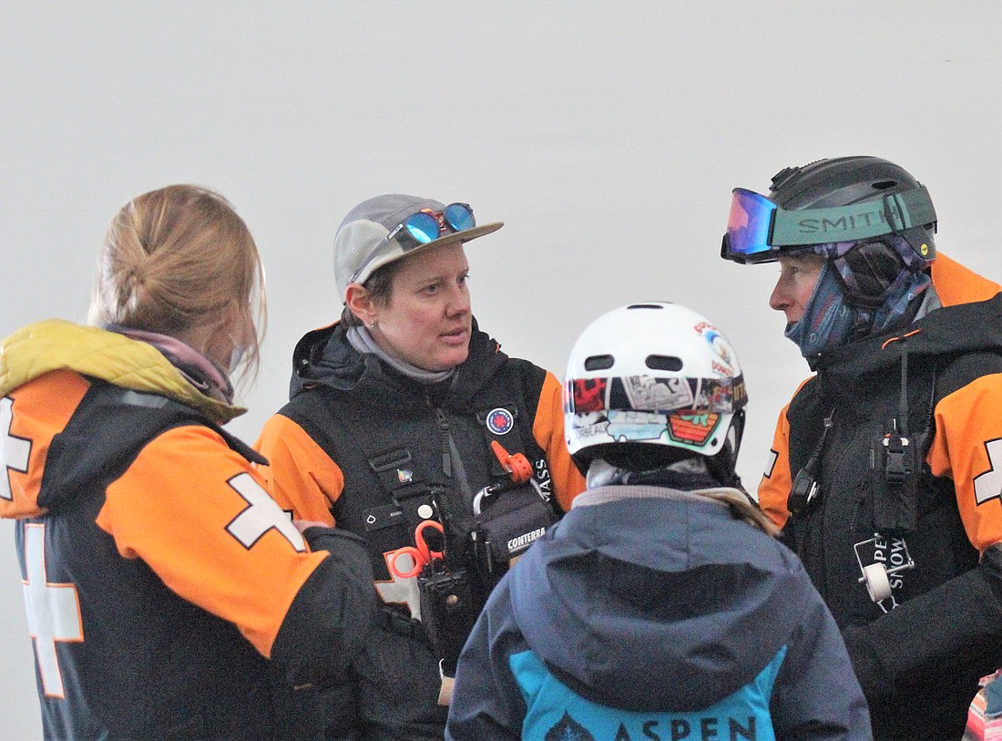 Ski patrollers Whitney Wickens, Caroline Kamm and Liz Bergdahl speak with a young participant at a Junior Ski Patrol clinic on March 25 at Snowmass Ski Area, Colo. The clinic included patrollers at Snowmass like Kamm as well as some from Buttermilk Mountain, like Wickens and Bergdahl.