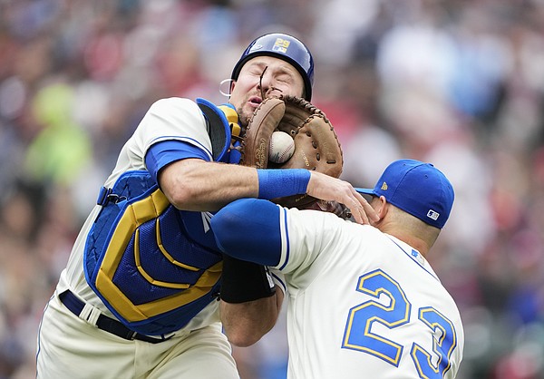 Seattle Mariners first baseman Ty France, right, grabs the hat of