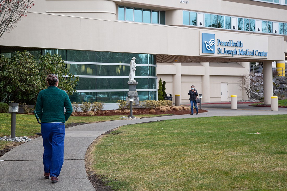 Staff walk outside PeaceHealth St. Joseph Medical Center in March 2022. PeaceHealth confirmed that it will close its allergy and immunology clinic at an undetermined date.