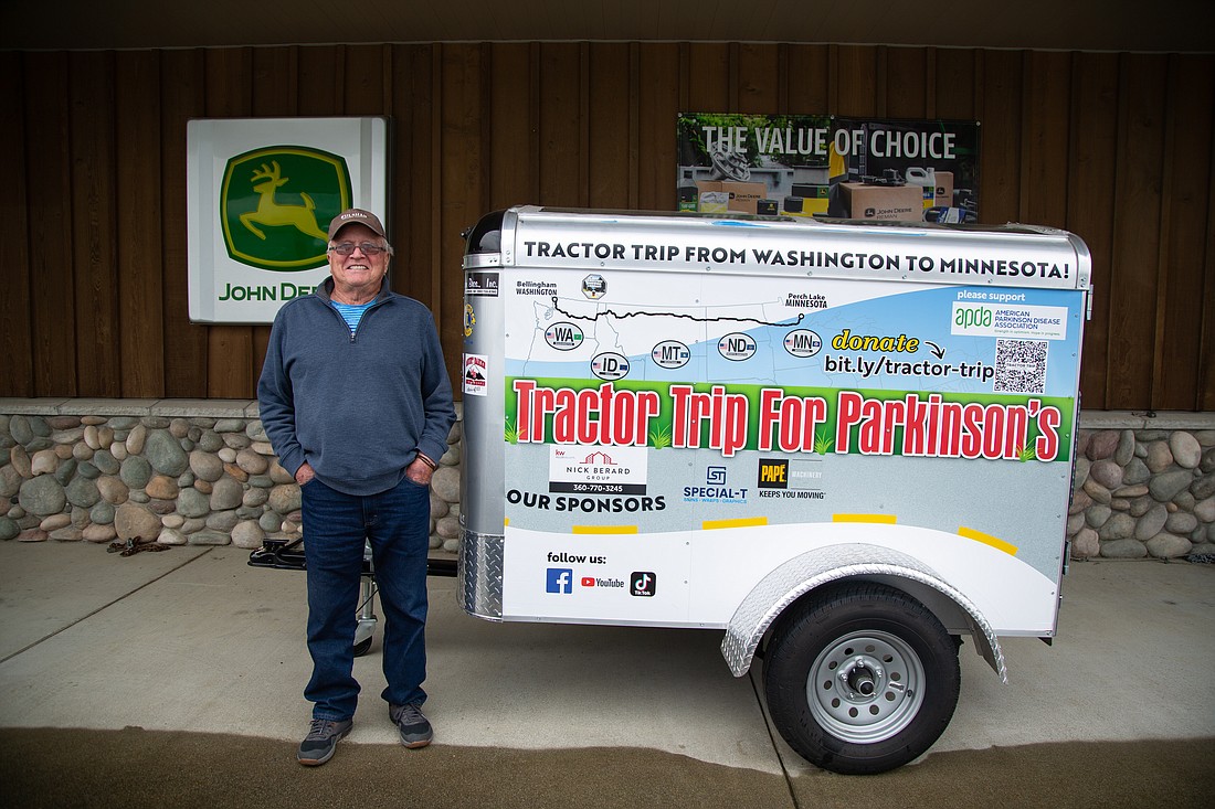 Mike Adkinson stands next to his trailer in April 2022. He pulled the trailer behind a John Deere tractor during a cross-country trip to raise money for Parkinson's disease in May 2022. This month, he's doing the trip again, this time with a loftier fundraising goal and added miles.