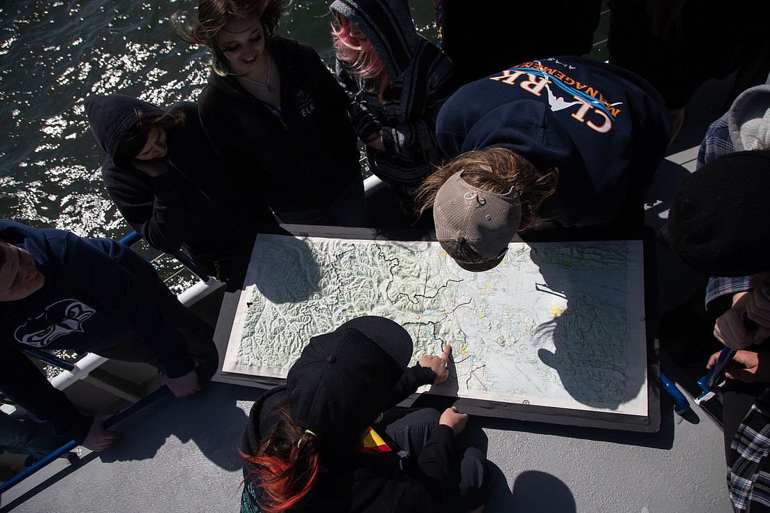Instructor and crew member Rowan Dart shows students waterways and mountains on a 3-D map of Northwest Washington. The curriculum of the field trip focuses on place-based learning to connect students' lessons with their location.
