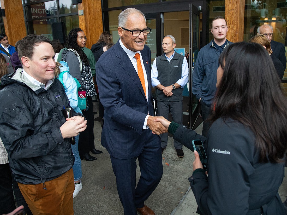 Gov. Jay Inslee shakes hands with audience members at a press conference at Western Washington University in October 2022. The governor announced May 1 he would not seek a fourth term.