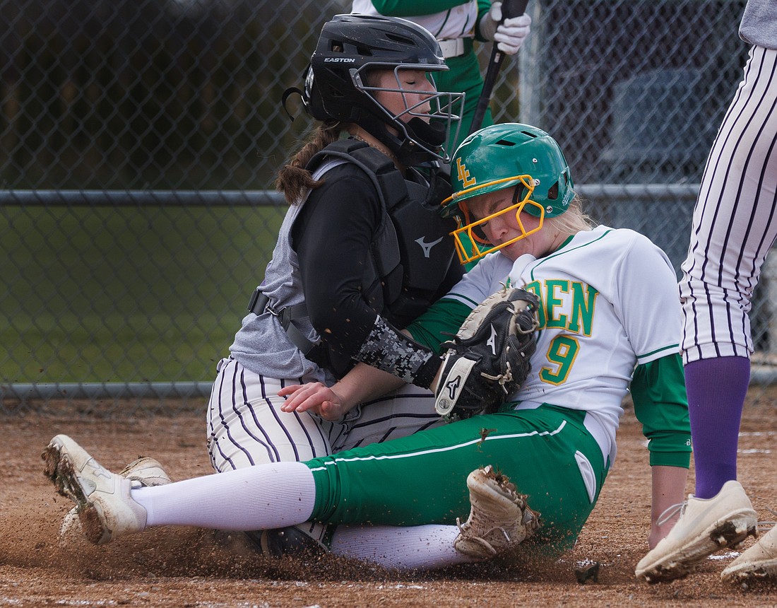 Nooksack Valley’s Alayna Dykstra tags out Lynden’s Childrey DeJong at home plate April 13 during a 17-6 win for the Lions over the Pioneers.