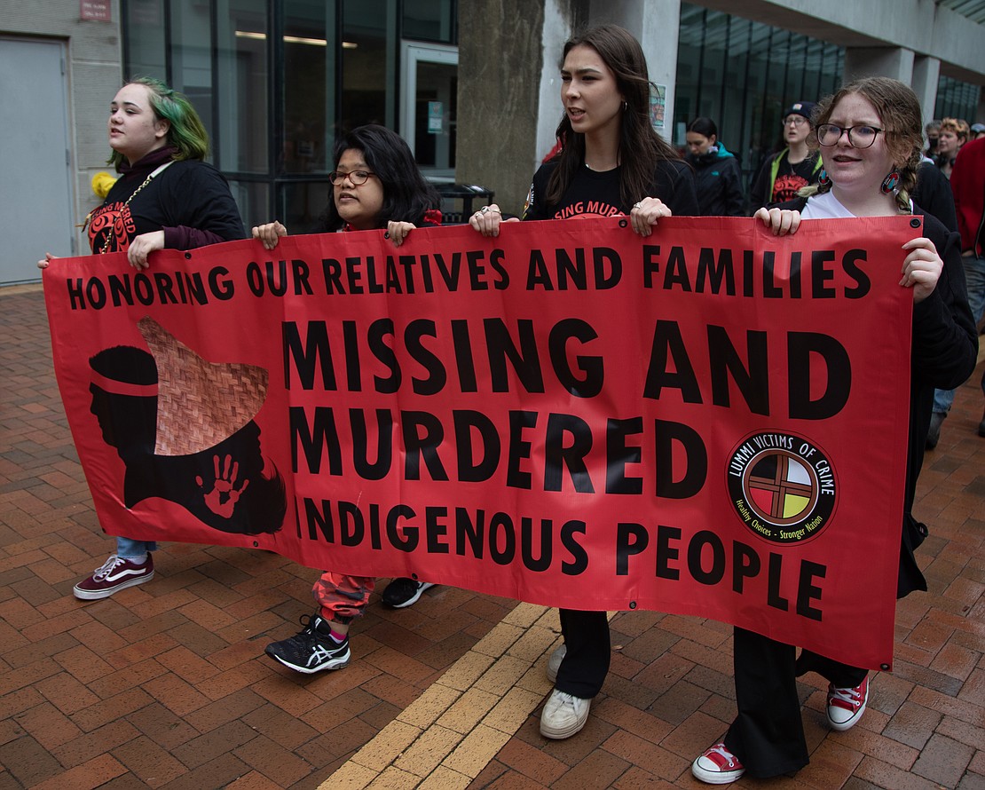 Dozens of people, including Tanisha James, Cristine James and Sage Reynolds, walk May 5 through Western Washington University to honor Missing and Murdered Indigenous Persons.
