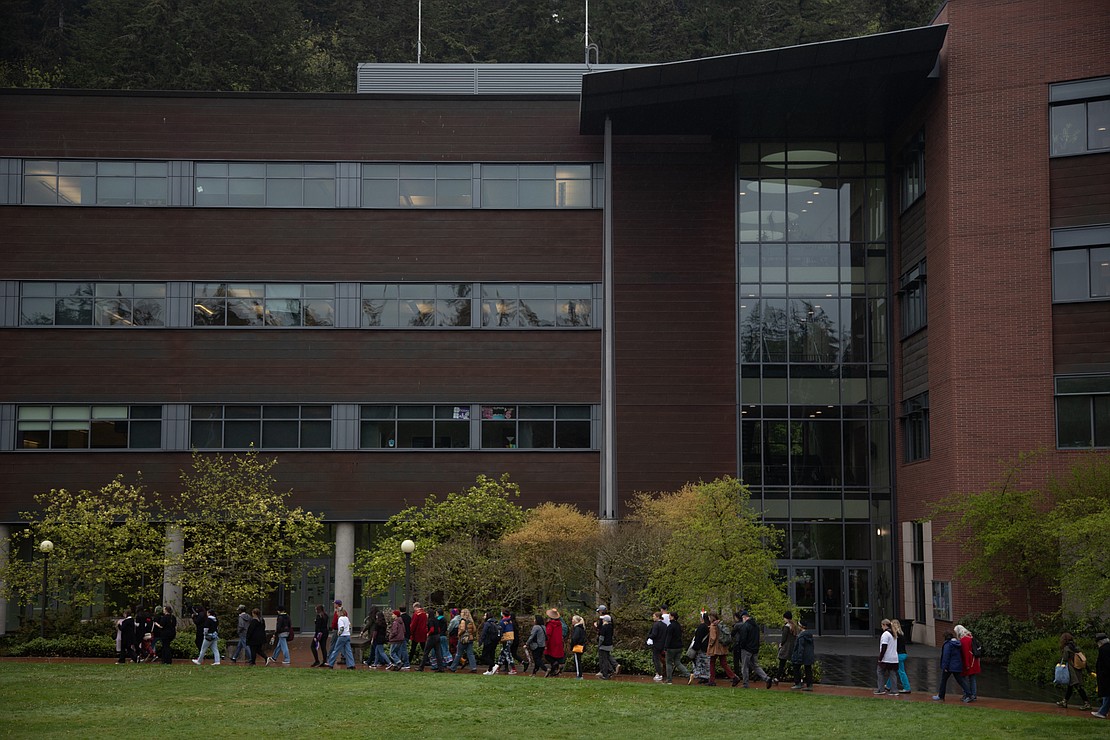A train of marchers pass the Communications Facility at Western Washington University, chanting the names of missing and murdered indigenous people.