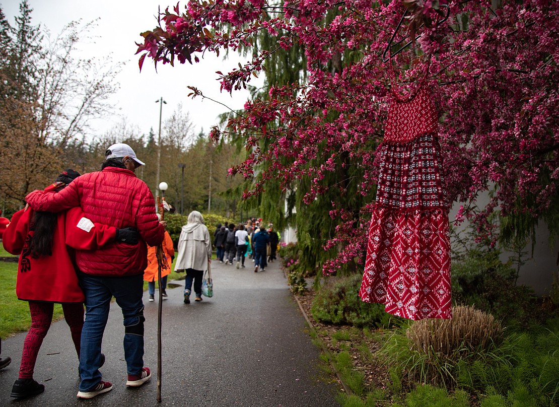 A red dress hangs from a cherry tree to honor missing and murdered indigenous people. Dozens of red shirts, dresses and jackets hung along the walk through campus.