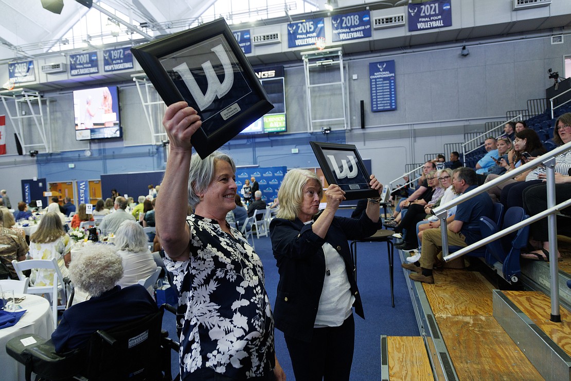 Laura Healy, left, and Joane Larson Ischer stop for a photo May 20 to hold up their Western Washington University varsity letters during an award ceremony at Carver Gymnasium. The women were two of nearly 200 former athletes and coaches from 1968–81 to receive varsity letters on Saturday.