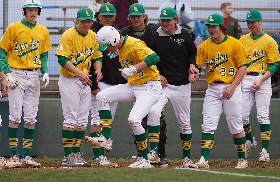 Lynden players watch as Lane Simonsen stomps on home plate after hitting a three-run homer April 21 in a game against Meridian.
