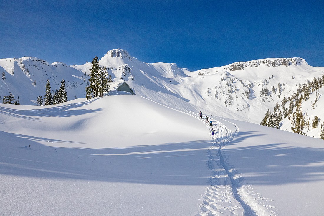 Snowshoers in March follow the deep tracks past the Heather Meadows Visitor Center on their way to Artist Point.
