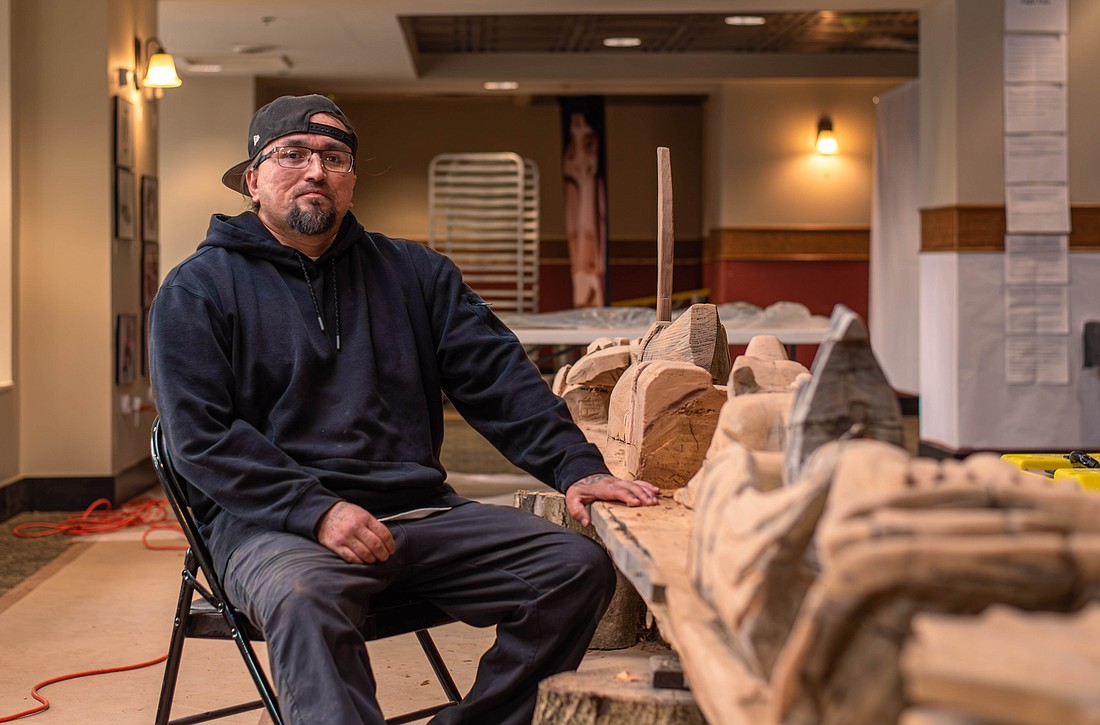Lummi Nation artist Jason LaClair sits next to his latest project, a story pole, in Hotel Leo. The pole can be seen at Hotel Leo from 6-10 p.m. June 2 during the Downtown Bellingham Partnership's First Friday Art Walk.