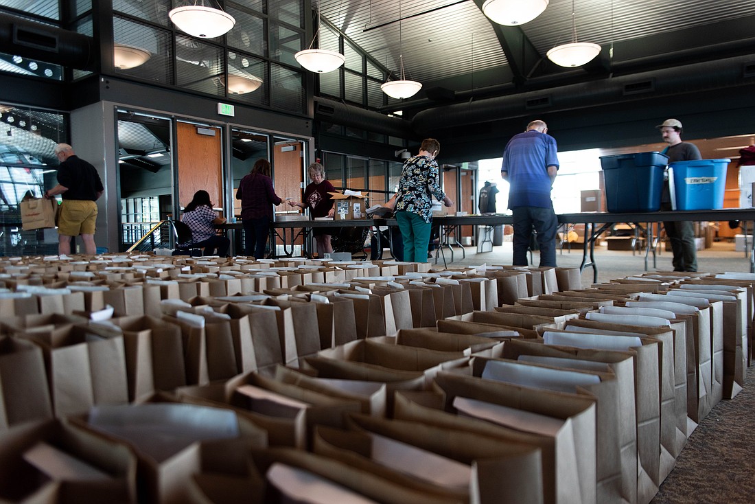 Hundreds of bags line the floor of the Dome Room in the Bellingham Ferry Terminal May 25 as Ski to Sea volunteers fill team packets.