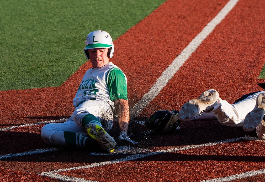 Lynden senior Kaedan Hermanutz slides safely into home after stealing on a wild pitch.