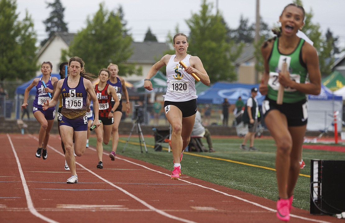 Sehome's Triya Mitchell, middle, watches as Tumwater's Ava Jones crosses the finish line less than 2 seconds ahead of her during the 2A girls 4X200 relay finals.