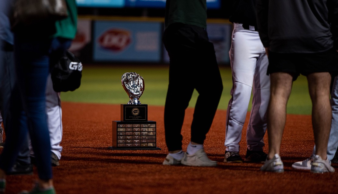 Tumwater's first-place trophy sits on the infield as the team mingles with family and friends.