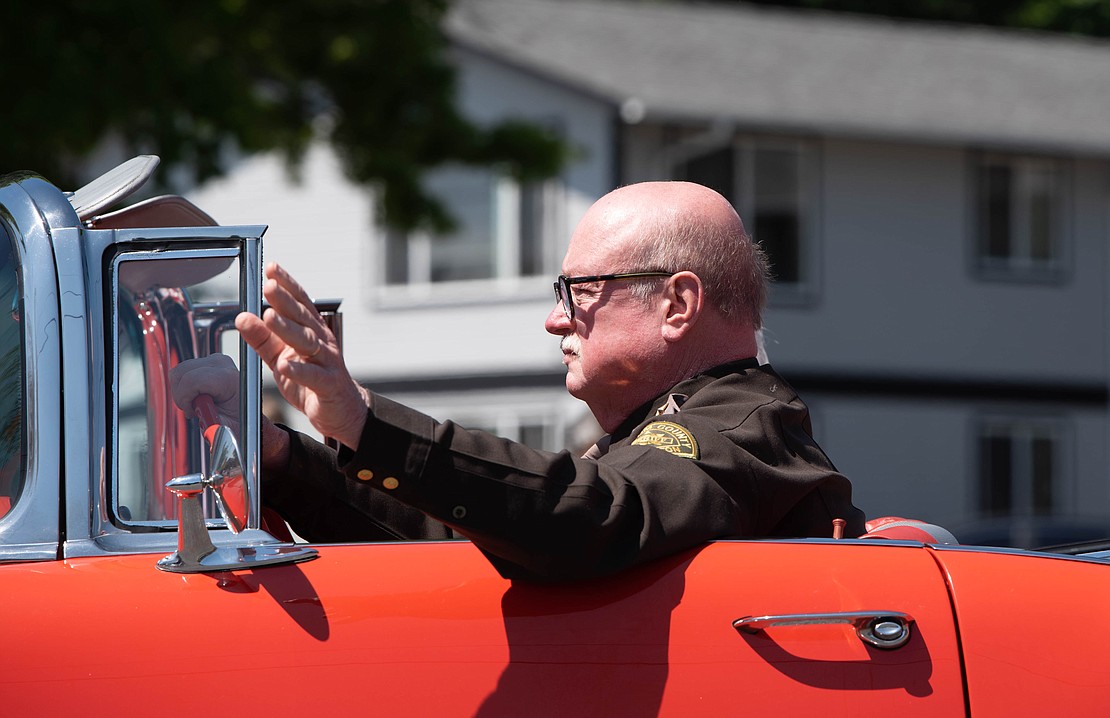 Whatcom County Sheriff Bill Elfo, the parade's grand marshal, drives an old Chevrolet.