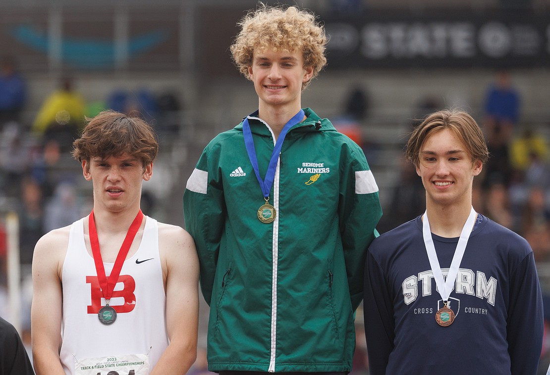 Sehome's Zack Munson, middle, is joined by Bellingham's William Giesen, left, and Squalicum's Chase Bartlett on the podium following the 2A boys 800-meter run finals. Munson won with a time of 1:54.59, earning his second title of the meet.