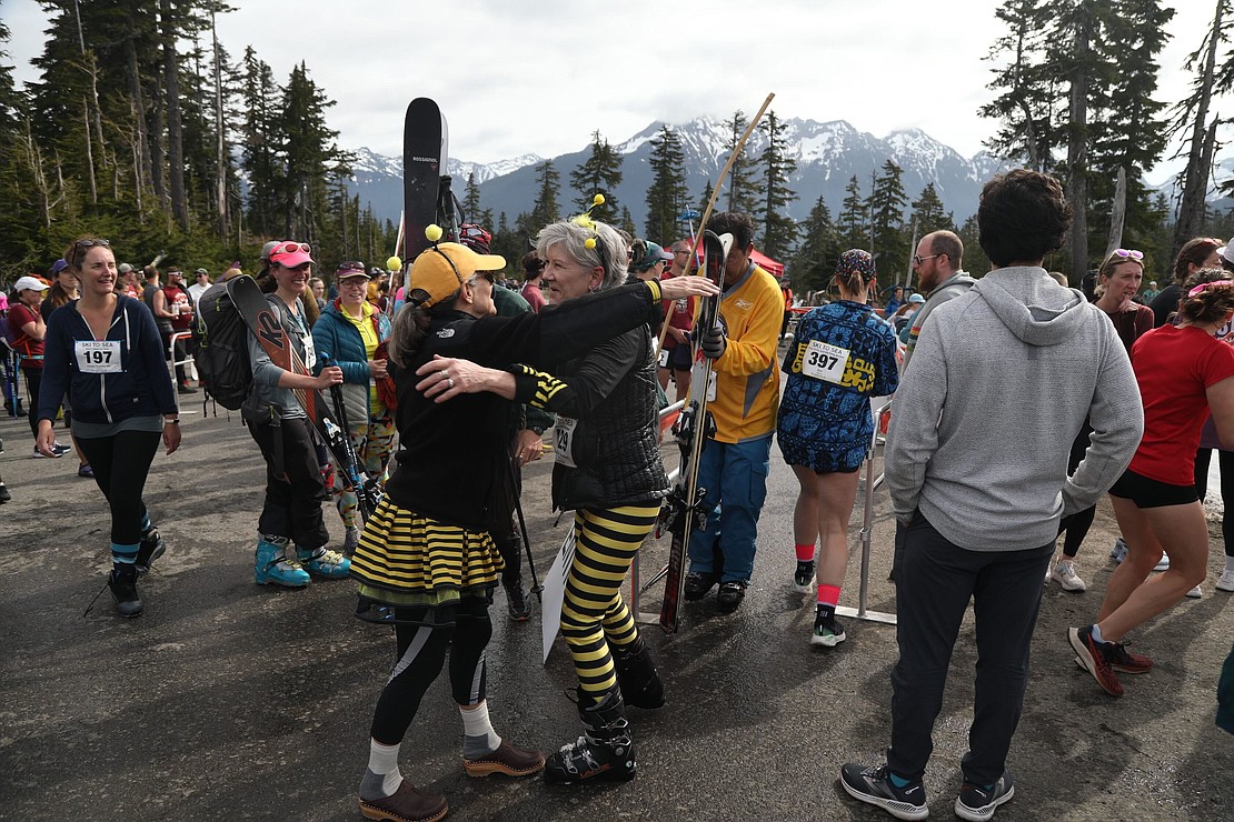 Becky Brunk, right, hugs teammate Deb Gordon of Oldies But New-Bees after Brunk finished the downhill ski leg in 50:42:9.