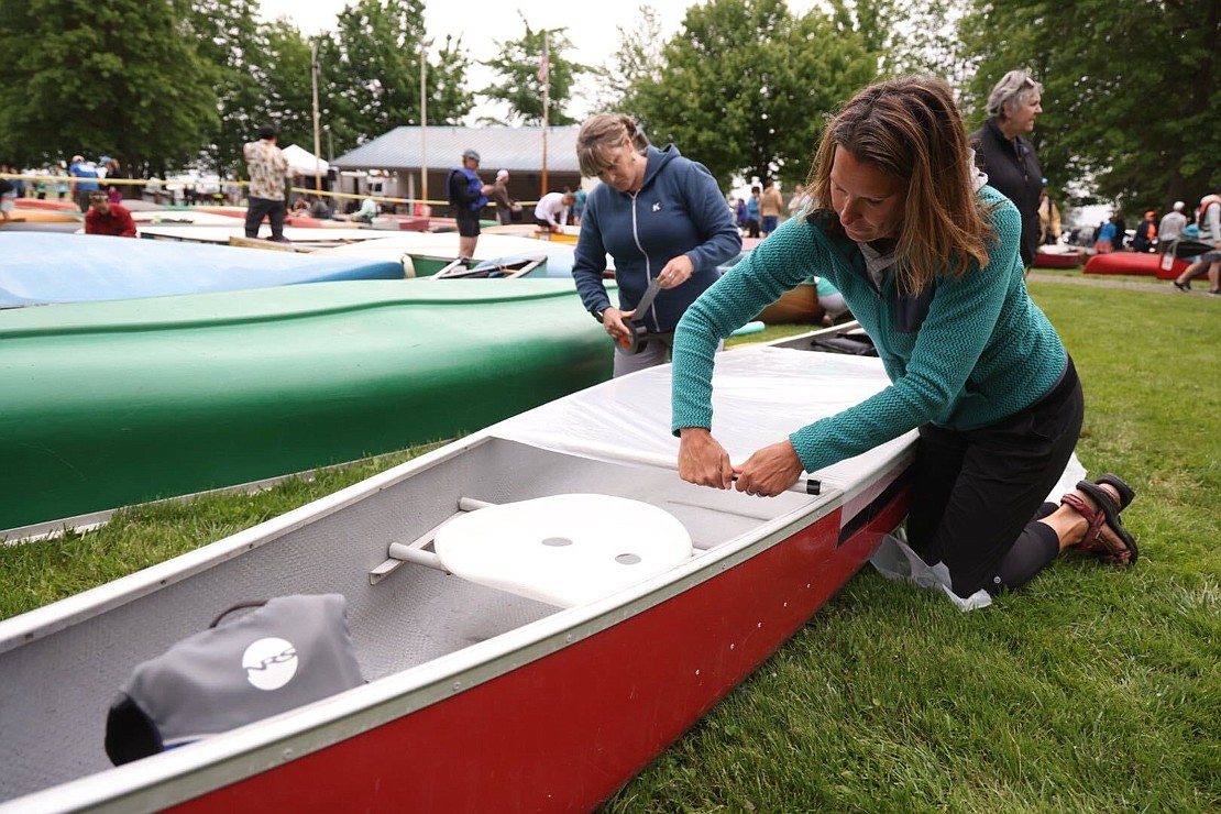 Kathleen Hall and Marisa Bamesberger of Emergency Respone Team tape their canoe to keep water out during the fifth leg.