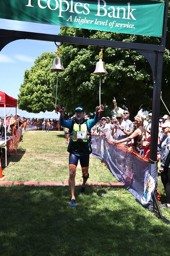Jeff Hilburn of Birch Equipment rings the bell at the finish line after finishing the sea kayak leg. Birch Equipment finished the race in 5:54:43.3, about five minutes faster than last year.