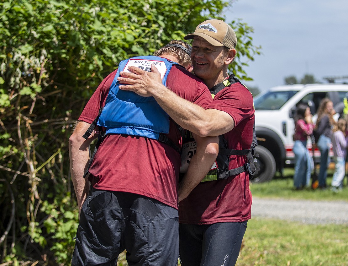 Vendovi's Scott Decker hugs canoe teammate George McLeod after finishing the fifth leg.