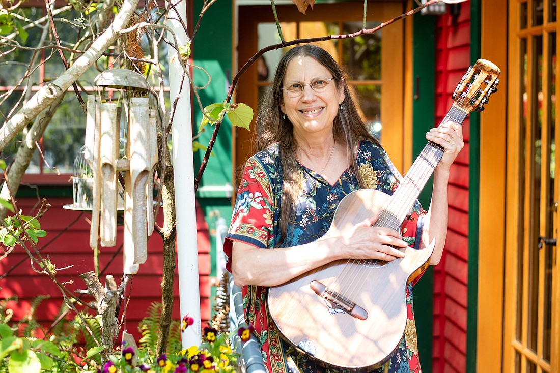 Fl!p Breskin holds her guitar in her backyard. When she moved to the Columbia neighborhood in 1999, Breskin said she connected with her neighbors through gardening, though she had never done it prior to her move.