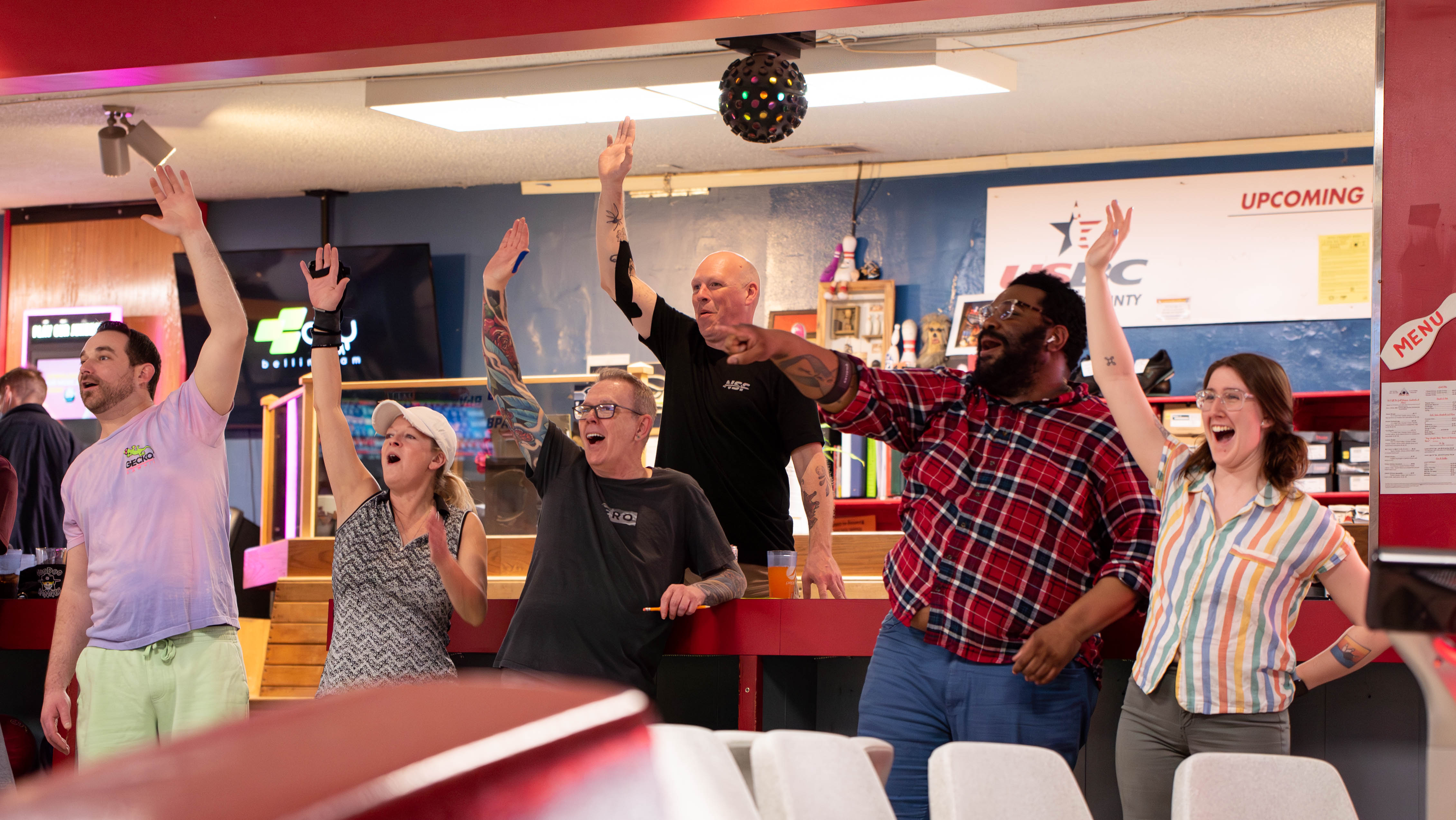 Thursday night bowlers raise their hands April 27 as a fellow league member leaves a five-pin at 20th Century Bowl. Traditionally, a bowler owes everyone a drink if they miss the pin — however, Social Club leaguers jokingly promise each other more than just a drink.