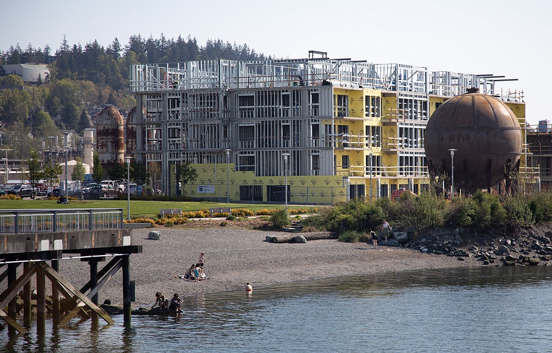 People enjoy the sunshine at Waypoint Park in May 2023. Three condominium buildings are under construction by Harcourt Developments on the waterfront. A later project will transform the historic brick Boardmill Building into a hotel, conference center and residences.