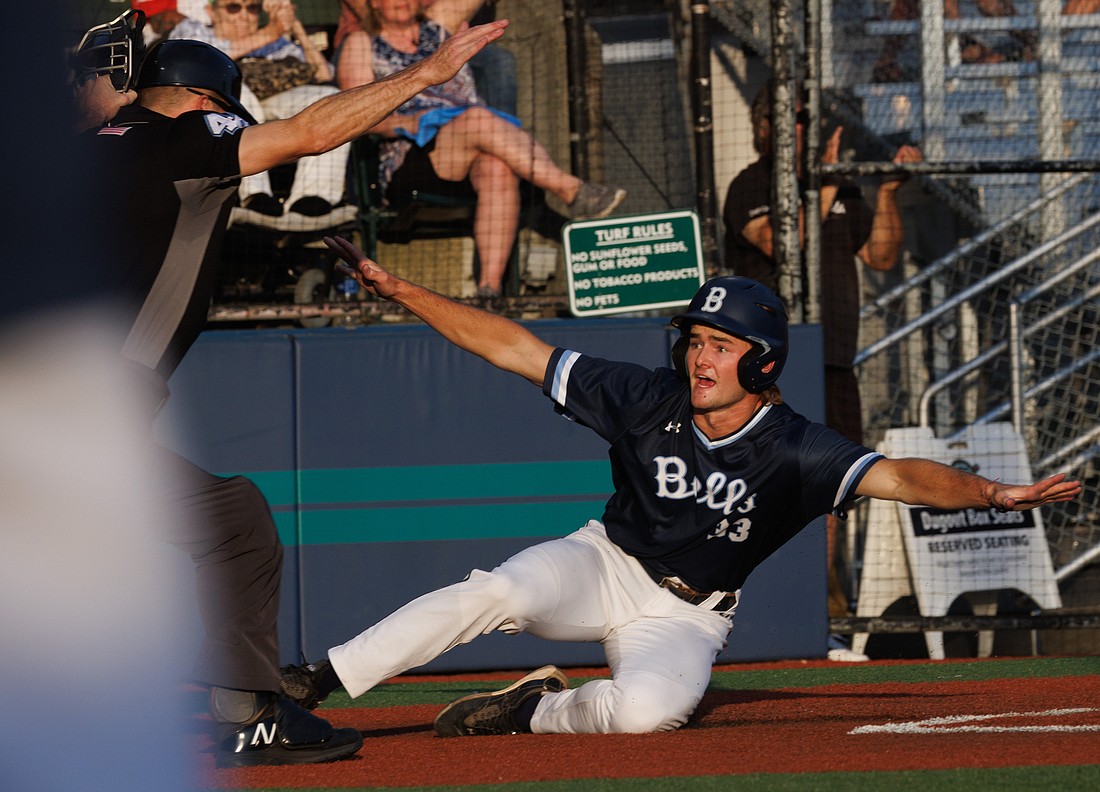 Sliding home, the Bellingham Bells' Coleman Schmidt spreads his arms while looking for the umpire's call July 6 in a game against the Kamloops NorthPaws. Schmidt was ruled safe for the tying score.