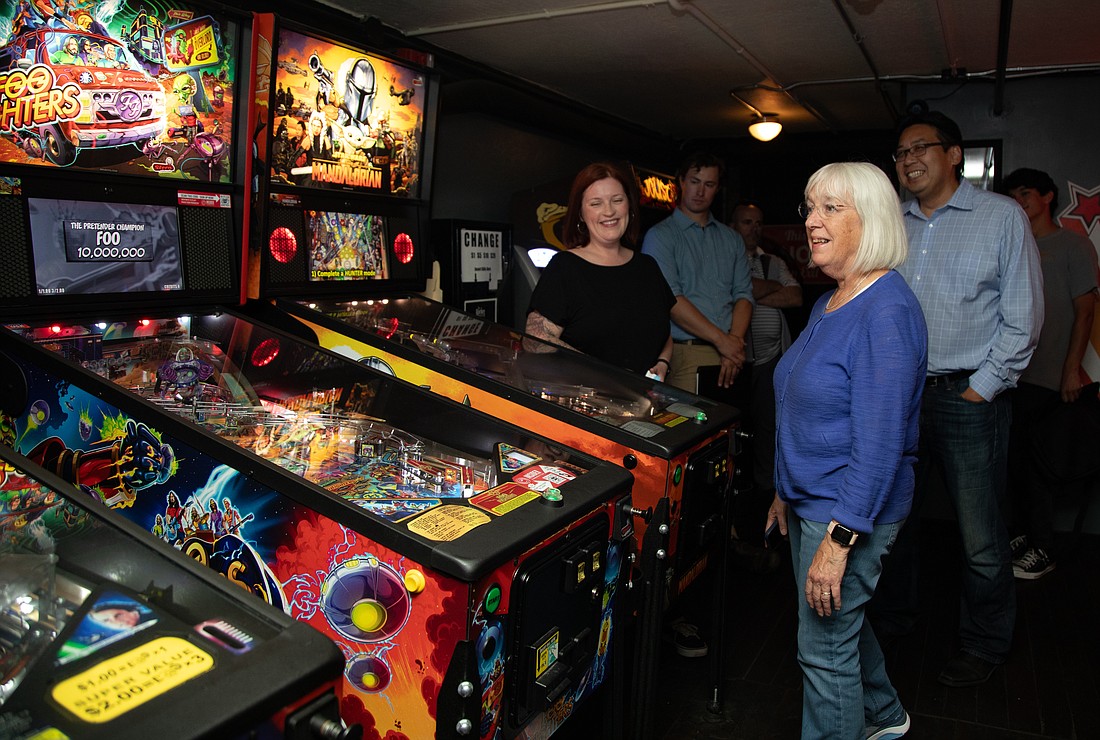 Sen. Patty Murray looks at pinball machines at The Racket on Monday, Aug. 7, while venue owner Hollie Huthman looks on.