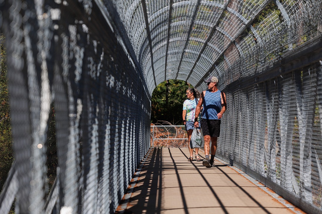 Nick Pate and Melissa Denmark, of Snohomish, look out from the new bridge over the Burlington Northern Santa Fe railroad track Aug. 16 in Larrabee State Park. Washington State Parks built a new bridge that provides safe passage between Clayton Beach and the Lost Lake parking lot.
