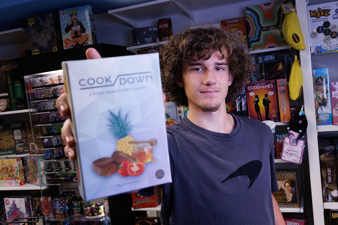 Jimmy Rust, a student at Squalicum High School, holds a card game that he created and is now in five local stores, including The Comics Place, on Aug. 24 in Bellingham. The card game, Cookdown, involves creating meal plans and having fellow players judge that meal to be a winner.