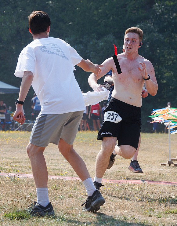 Nic Wasik, right, throws a timing chip to teammate Kenny Baker.