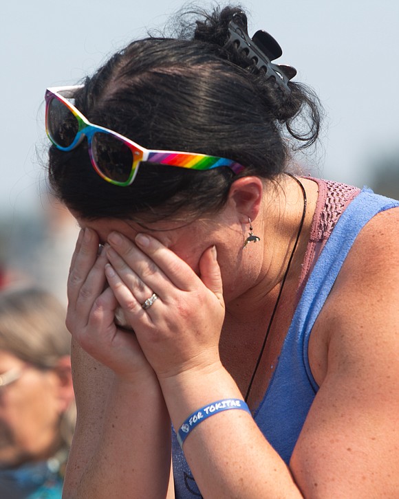 A Tokitae supporter cries while listening to whale sounds recorded from a pod of Southern Resident orcas gathering near San Juan Island on the day Tokitae passed.
