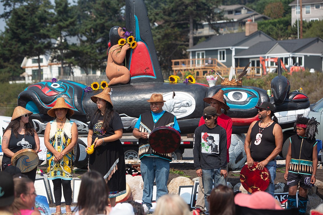 Members of the Lummi Nation gather to sing in front of the totem.