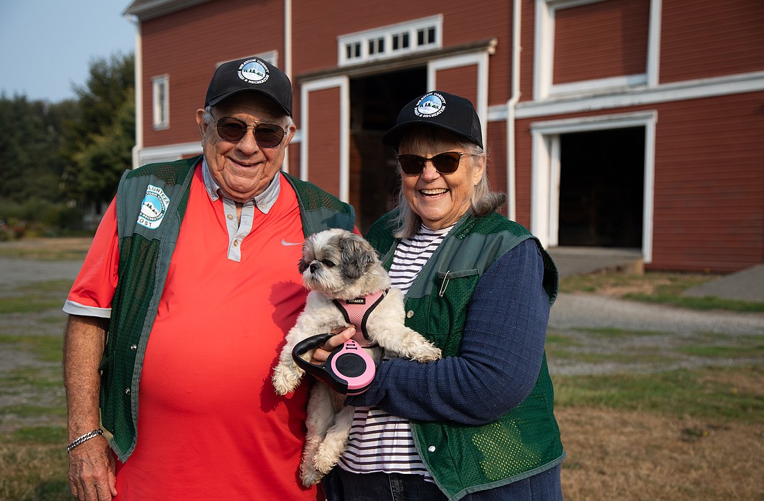 Bill, left, and Jan Ellingson stand with their dog Angel on Thursday, Aug. 24 at Hovander Homestead Park in Ferndale. The pair have volunteered and cared for the animals at the park for 13 years.